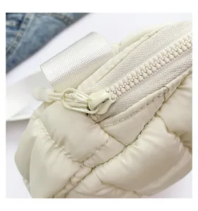 Detail shot of stylish quilted puffer crossbody bag showing soft texture and sturdy white zipper.