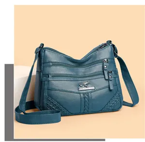 Detailed view of women soft leather multi layer cross body bag with metal logo and multi zippers.