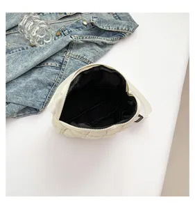 Detailed close-up view of the white quilted crescent bag showing internal black lining.