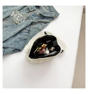 Detail view of white quilted crossbody bag interior, showing compact capacity and stylish design.