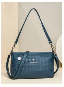 Detailed close-up of a stylish blue quilted shoulder bag with metal logo and strap.
