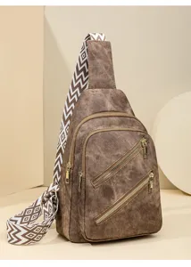 Detailansicht braune Umhaengetasche, geometrischer Gurt, Doppeltaschen, laessiger Reisestil.