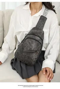 Vintage distressed chest bag for women, casual sling crossbody bag with double zipper and wide strap.