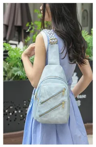 Detailansicht der hellblauen Damen Freizeittasche als Brusttasche am Modell, mit Reißverschluss.
