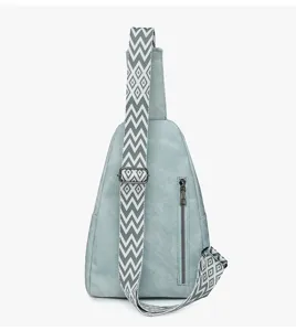 Close-up detail view of casual womens sling bag featuring wide chevron strap and zipper.