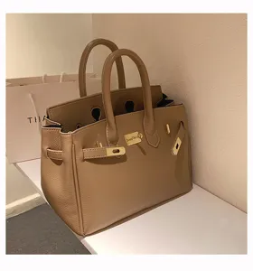 Elegante khakifarbene Damentasche aus Leder mit klassischem Metallverschluss und zwei Henkeln.