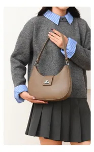 Chic brown leather shoulder bag for women, elegant crescent design with metal clasp.