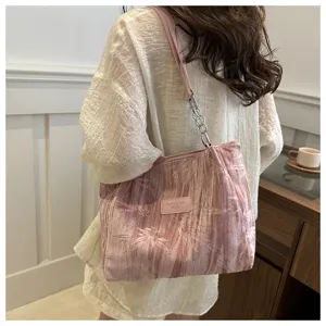 Detailed close-up view of a pink pleated shoulder tote bag featuring chic chain strap.