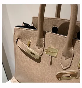Nahaufnahme der strukturierten Lederhandtasche mit eleganten goldenen Beschlägen und Schloss.