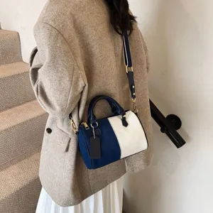 Detail view of the stylish color-block Boston handbag, showcasing premium texture and handles.