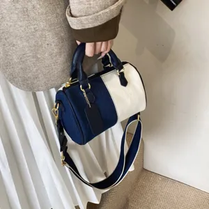 Detail view of two-tone Boston bag, showing contrast color design and wide shoulder strap style.