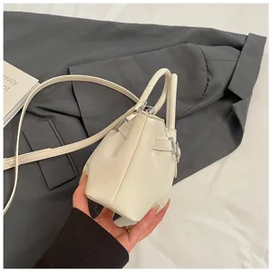 White patent leather bucket bag with top handles and strap, stylish cross-body purse for women