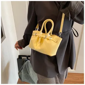 Yellow patent leather handbag detail, stylish shoulder cross-body bucket bag for women.