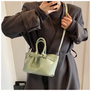 Detailed view of the stylish light green bucket bag with metal buckle and shoulder strap.