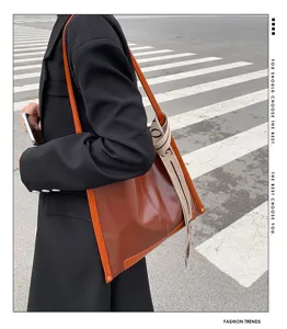 Vista di dettaglio della elegante borsa a tracolla in pelle marrone con nastro.