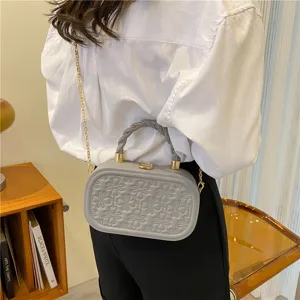 Stylish grey hard shell crossbody box bag featuring metal chain and elegant embossed pattern.