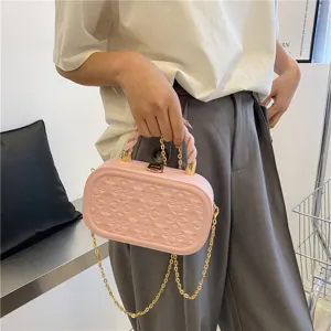 Pink embossed hard case handbag detail featuring a stylish chain strap and twist handle.