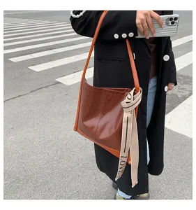 Vista dettagliata della borsa a tracolla capiente, elegante design a secchiello con colori a contrasto.