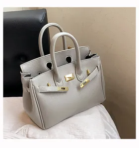 Elegante graue Handtasche aus Leder mit goldenen Beschlägen, klassisches Design für Damen.