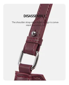 Close-up detail of burgundy leather handbag strap, metal ring hardware, detachable design.