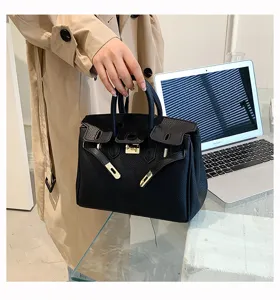 Detailansicht der schwarzen Damen-Lederhandtasche mit goldener Hardware und klassischer Klappe.