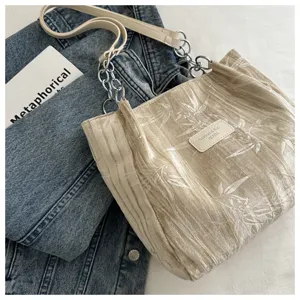 Detailed view of trendy pleated velvet tote bag with metal chain strap for daily commuting.