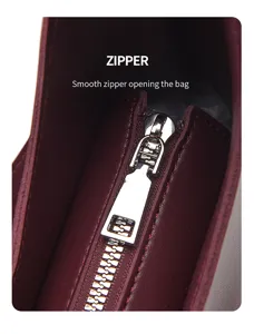 Detailed view of the smooth metal zipper on a stylish burgundy leather women shoulder bag.
