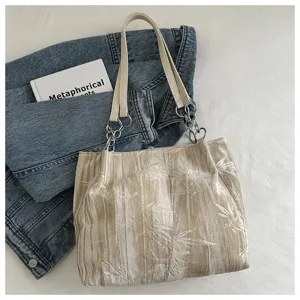 Detailed view of women beige pleated velvet tote bag with chic chain shoulder strap for daily use.