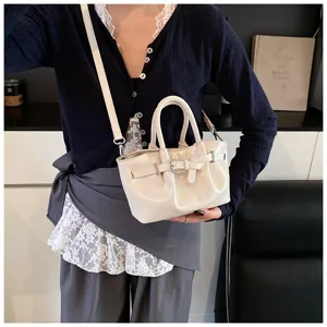 Chic patent leather handbag for women, stylish bucket bag with top handle and crossbody strap.