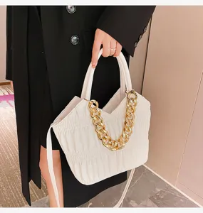 Close-up detail view of stylish white pleated women handbag featuring chunky gold chain strap.