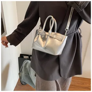 Silver metallic top handle crossbody bag for women, stylish mini tote with buckle strap detail.