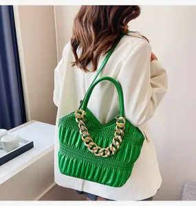 Detail view of a stylish green ruched shoulder bag showcasing the elegant chunky gold chain accent.
