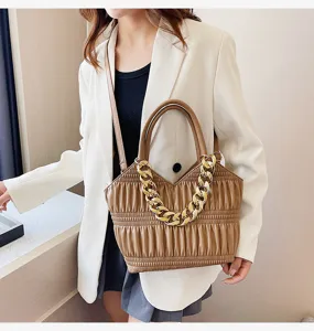Detailed view of the stylish pleated brown handbag with a chunky gold chain for women.