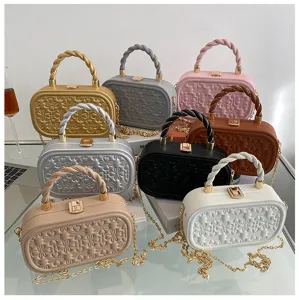 Elegant embossed box bag with chain strap and twisted handle, chic retro crossbody design.