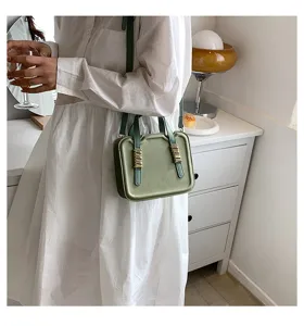 Green mini biscuit shoulder bag with unique handle detail for daily casual outfits.