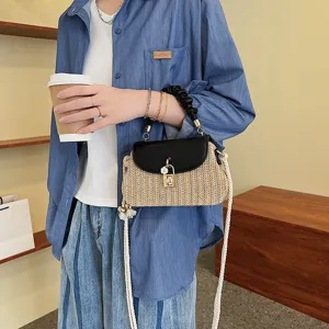 Modieuze schoudertas voor dames, stijlvolle strooien crossbody tas met chique zwarte leren flap.
