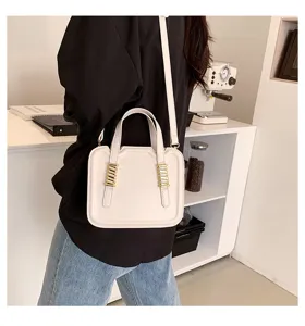 Detailed view of stylish white shoulder bag with chic metal hardware in clean daily lifestyle setup.