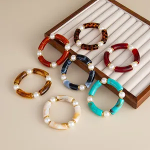 Colorful resin tube bracelets with pearl beads on a jewelry display tray