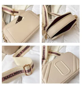 Élégant sac bandoulière appareil photo beige avec sangle large et double fermeture éclair.