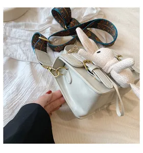 Retro witte schoudertas met schattige konijnenhanger en etnische schouderband.