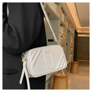 Sac bandoulière appareil photo en cuir blanc élégant pour femme avec large sangle.