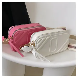 Sac bandoulière appareil photo élégant pour femme avec sangle large et double compartiment.