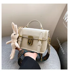 Detailopname van vintage kleine tas met metalen slot en schattige konijnenhangdecoratie.