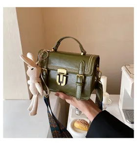 Gedetailleerd overzicht van de retro donkergroene handtas met metalen sluiting en schattig konijntje.