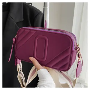 Sac bandoulière violet détail, sangle large et texture matelassée chic pour un usage.