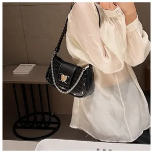 Black faux leather baguette shoulder bag with chain strap and heart clasp, detailed view.