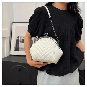 Detailed view of the elegant white chevron quilted kiss-lock shoulder bag with chic chain.