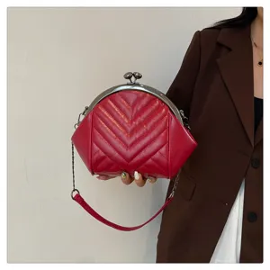 Stylish red quilted leather shoulder bag with metal kiss-lock frame and chain strap.