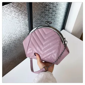 Close-up of a elegant purple chevron quilted kiss-lock handbag with a metal chain strap.