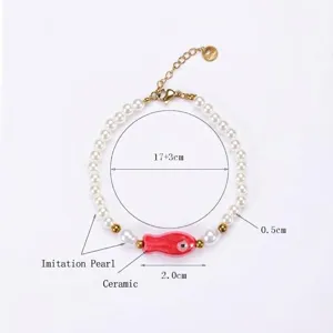 Vue détaillée du bracelet en perles fait main avec poisson en céramique rouge.